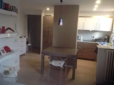 a kitchen with a table and a chair in a room at Appartamento zona porto a 10 mn a piedi dal mare in Nice