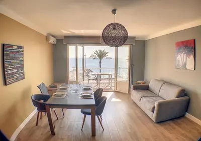 a living room with a table and a couch at Charmant 2 pièces FACE à la MER- Cagnes sur Mer in Cagnes-sur-Mer