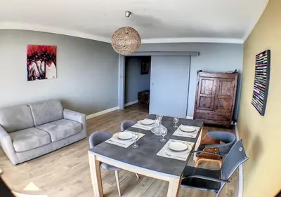 a living room with a table and a couch at Charmant 2 pièces FACE à la MER- Cagnes sur Mer in Cagnes-sur-Mer