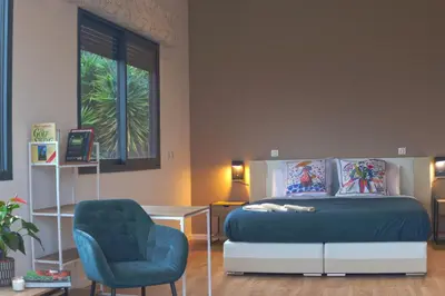 a bedroom with a bed and a chair and a window at STAYnGOLF in Cagnes-sur-Mer