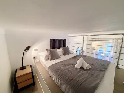 a bedroom with a large bed with a lamp and a window at Nestor&Jeeves - LES CYPRES - central - very close sea in Nice