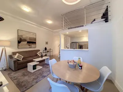 a living room with a table and chairs and a couch at Nestor&Jeeves - LES CYPRES - central - very close sea in Nice