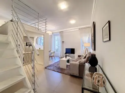 a living room with a staircase and a couch and a television at Nestor&Jeeves - LES CYPRES - central - very close sea in Nice
