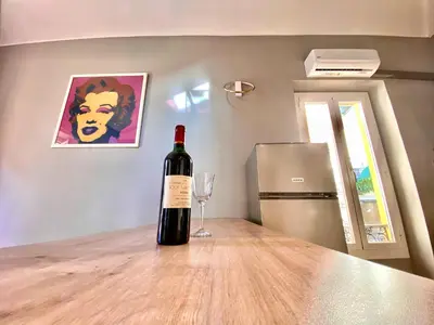 a bottle of wine sitting on a table with a wine glass at Lovely & sunny loft heart of Nice with A/C! in Nice