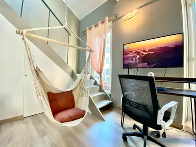 a hammock in a room with a desk and a tv at Lovely & sunny loft heart of Nice with A/C! in Nice