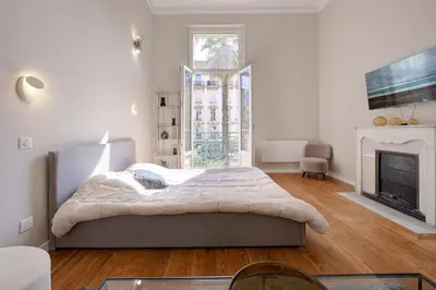 a white bedroom with a bed and a fireplace at Maison Bianchi - Clemenceau in Nice