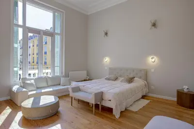 a white bedroom with a large bed and a couch at Maison Bianchi - Clemenceau in Nice