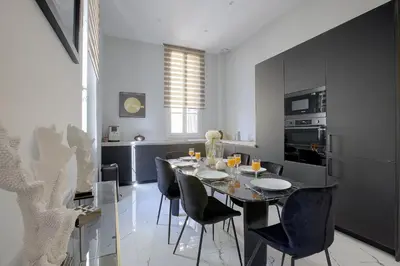 a dining room with a black table and chairs at Maison Bianchi - Clemenceau in Nice