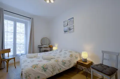 a white bedroom with a bed and a window at Maison Bianchi - Saint Philippe in Nice