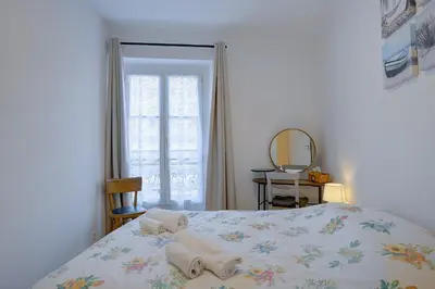 a bedroom with a bed and a mirror and a window at Maison Bianchi - Saint Philippe in Nice