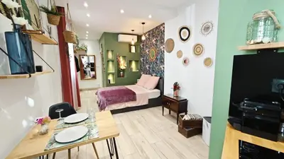a room with a bed and a table with a dining room at Studio de charme climatisé Gare Riquier in Nice