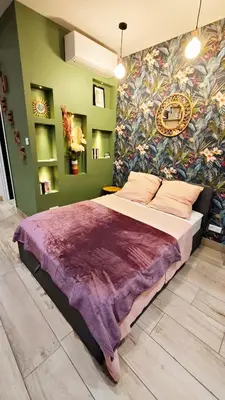 a bedroom with a large bed with a colorful wall at Studio de charme climatisé Gare Riquier in Nice