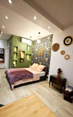 a bedroom with a bed and a painting on the wall at Studio de charme climatisé Gare Riquier in Nice