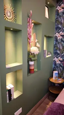 a room with green walls and shelves with a flower on the wall at Studio de charme climatisé Gare Riquier in Nice