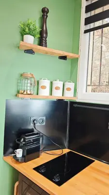 a kitchen with a counter with a stove and shelves at Studio de charme climatisé Gare Riquier in Nice