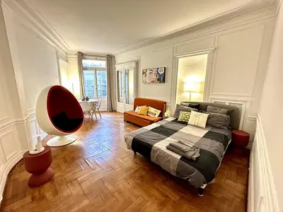 a bedroom with a bed and a chair in it at A Luxurious Apartment with AC on Promenade des Anglais in Nice