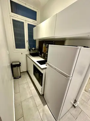 a kitchen with a white refrigerator and a window at A Luxurious Apartment with AC on Promenade des Anglais in Nice