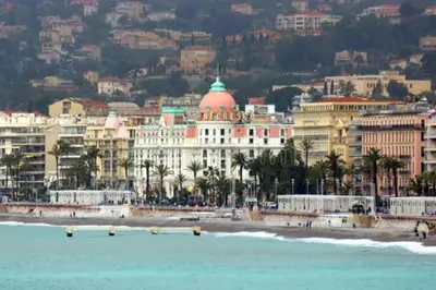a group of buildings on a beach with the ocean at A Luxurious Apartment with AC on Promenade des Anglais in Nice