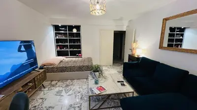 a living room with a couch and a large screen tv at John Homestay Room in Nice in Nice