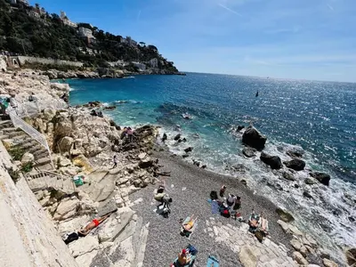 a group of people on a beach near the ocean at John Homestay Room in Nice in Nice
