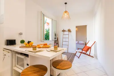 a kitchen with a white counter and a table at LE FLORIDA AP4340 By Riviera Holiday Homes in Villefranche-sur-Mer