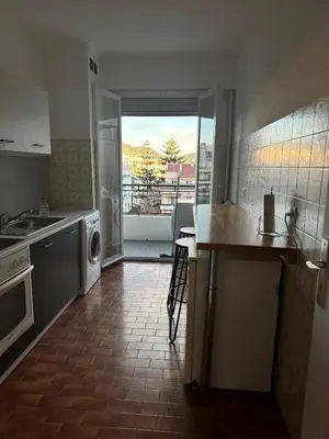 a kitchen with a sink and a counter with a table at Orangers Apartment in Nice