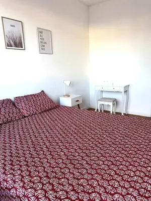 a bedroom with a red bed and a desk at Orangers Apartment in Nice