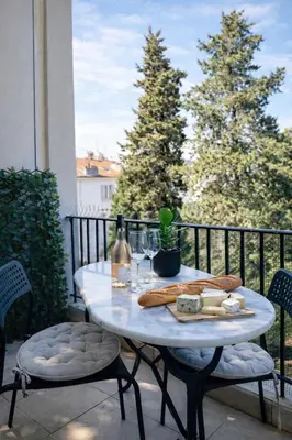 a table with bread and a bottle of wine on a balcony at T2 Carre Or Nice Rue Pietonne in Nice