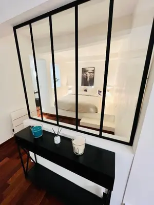a black table with a mirror in a bedroom at Vieux-Nice : 2 pièces type loft in Nice