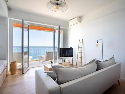 a living room with a couch and a view of the ocean at Apartment L'Angelina-2 by Interhome in Cagnes-sur-Mer