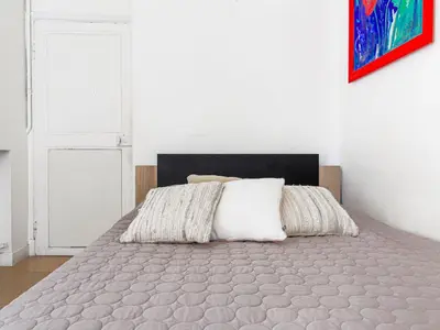 a bed in a white room with a bedspread at Apartment Hérold-2 by Interhome in Nice