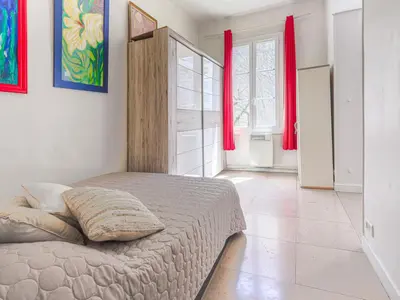 a bedroom with a bed in a room with red curtains at Apartment Hérold-2 by Interhome in Nice