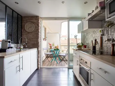 a kitchen with white cabinets and a table with chairs at Apartment Cros de Cagnes-1 by Interhome in Cagnes-sur-Mer