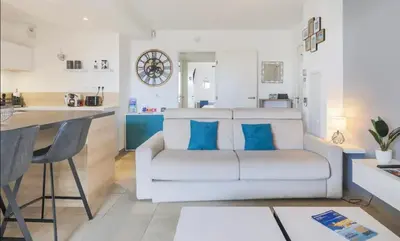 a living room with a white couch and a kitchen at Q&R Renting - Appartement luxueux et Suites design- Parking AC Mer in Nice