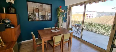a dining room with a wooden table and a large window at Appartement 90m2, climatisé 3 chambres in Nice