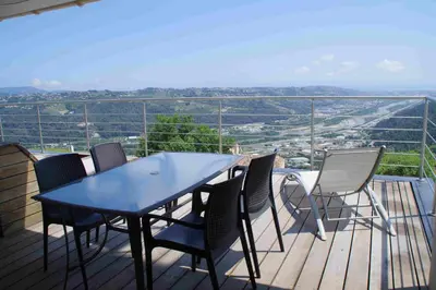 a table and chairs on a balcony with a view at 3 pièces dans le ciel in Gattières