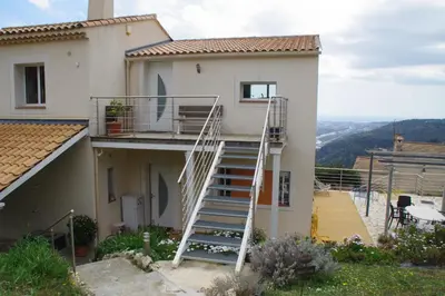a white house with a ladder on the side of it at 3 pièces dans le ciel in Gattières