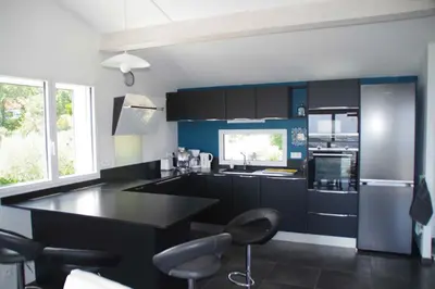 a kitchen with a black counter and blue cabinets at 3 pièces dans le ciel in Gattières