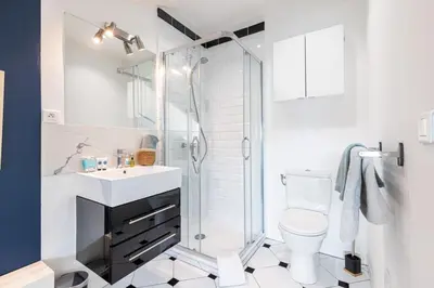 a white bathroom with a shower and a toilet at MY CASA - DEROULEDE - Superb Studio Suite w AC Downtown in Nice