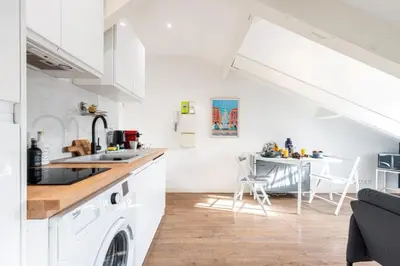 a white kitchen with a sink and a table at MY CASA - DEROULEDE - Superb Studio Suite w AC Downtown in Nice