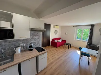 a kitchen and living room with a red couch at STUDIO CASSIN - next to tramway line 2 near airport in Nice