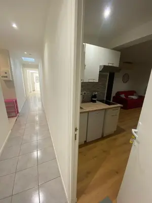 a kitchen with white cabinets and a tile floor at STUDIO CASSIN - next to tramway line 2 near airport in Nice