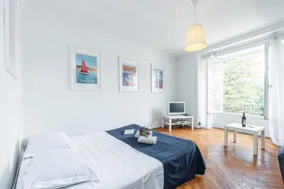 a white bedroom with a bed and a tv at MY CASA - JOFFRE 38 - Spacious one bedroom apartment in Nice