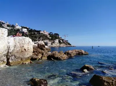 a group of people sitting on top of a rocky beach at Studio avec balcon à 7 min du port et de Garibaldi in Nice