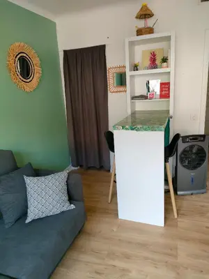 a living room with a couch and a counter at Studio avec balcon à 7 min du port et de Garibaldi in Nice