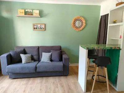 a living room with a couch and a table at Studio avec balcon à 7 min du port et de Garibaldi in Nice