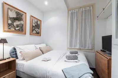 a bedroom with a white bed and a television at MY CASA - STALINGRAD 32 - Cosy Apartement close old Port in Nice