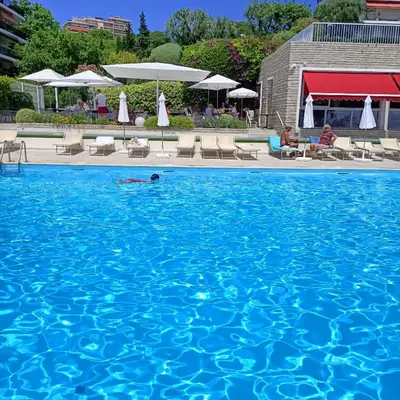 a person swimming in a large swimming pool at EXCEPTIONNEL 4 pieces vue panoramique baie des anges proche plage in Nice