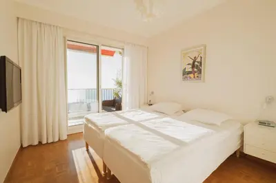 a white bedroom with a large bed and a window at EXCEPTIONNEL 4 pieces vue panoramique baie des anges proche plage in Nice