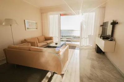 a living room with a couch and a television at EXCEPTIONNEL 4 pieces vue panoramique baie des anges proche plage in Nice